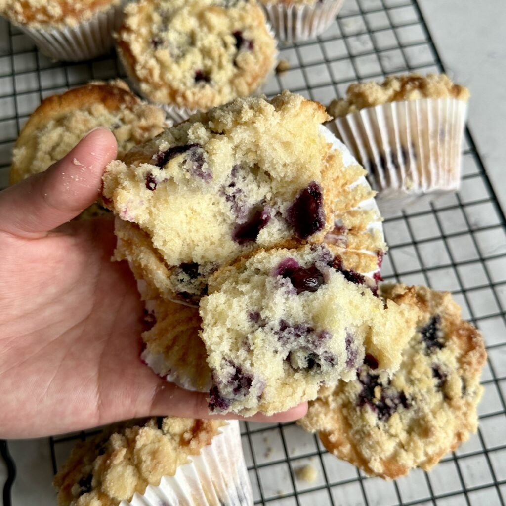 Blueberry lemon streusel muffins ripped open to expose the fluffy center of the muffins