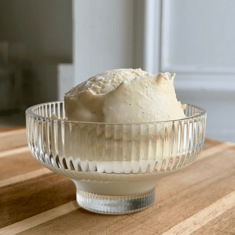 Two scoops of vanilla ice cream in a glass bowl