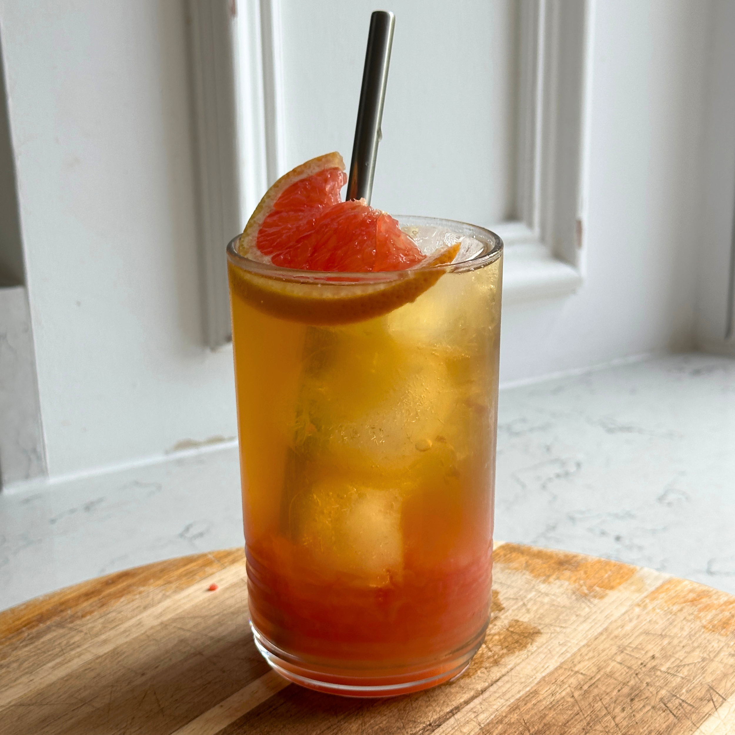 Glass of grapefruit oolong iced tea with a straw